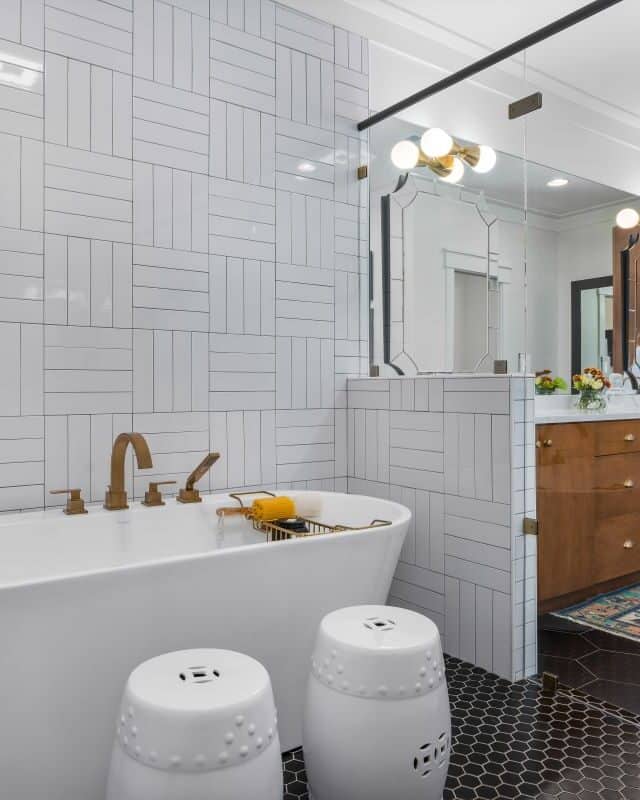 Modern bathroom with freestanding tub, wooden vanity, and stylish lighting fixtures.