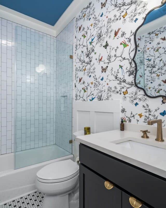 Elegant bathroom with floral wallpaper and modern fixtures.