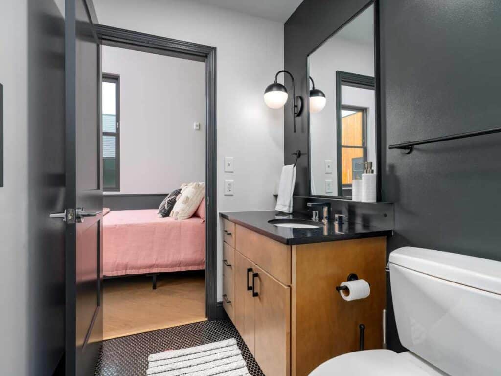 Modern Birmingham short-term rental bathroom with vanity and bedroom view.