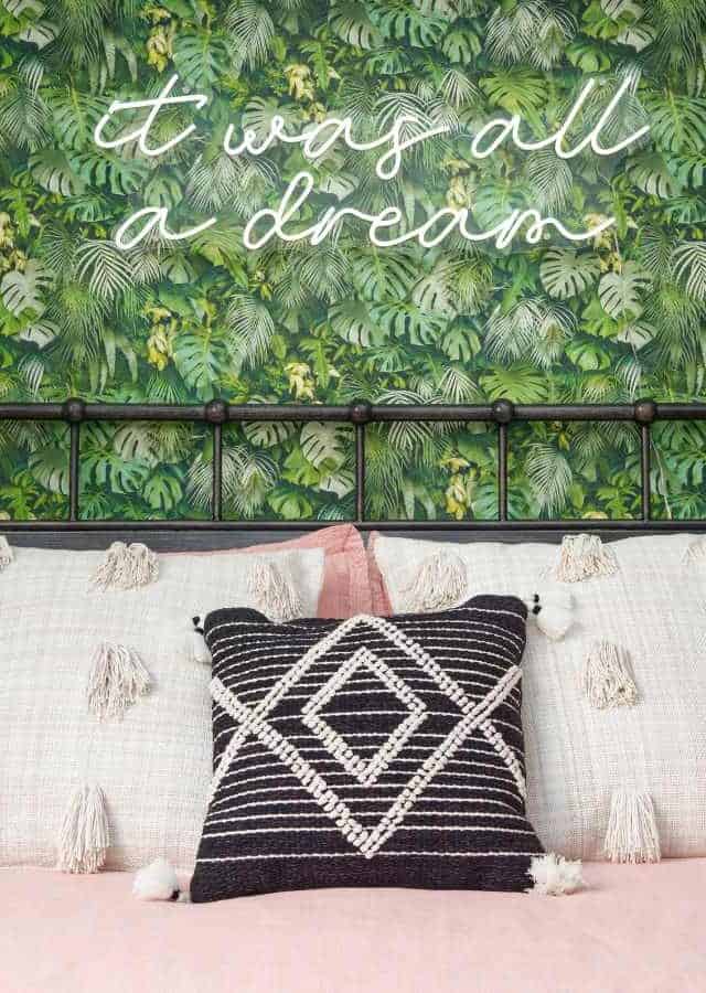 Elegant bedroom with lush green wall decor and cozy bedding.