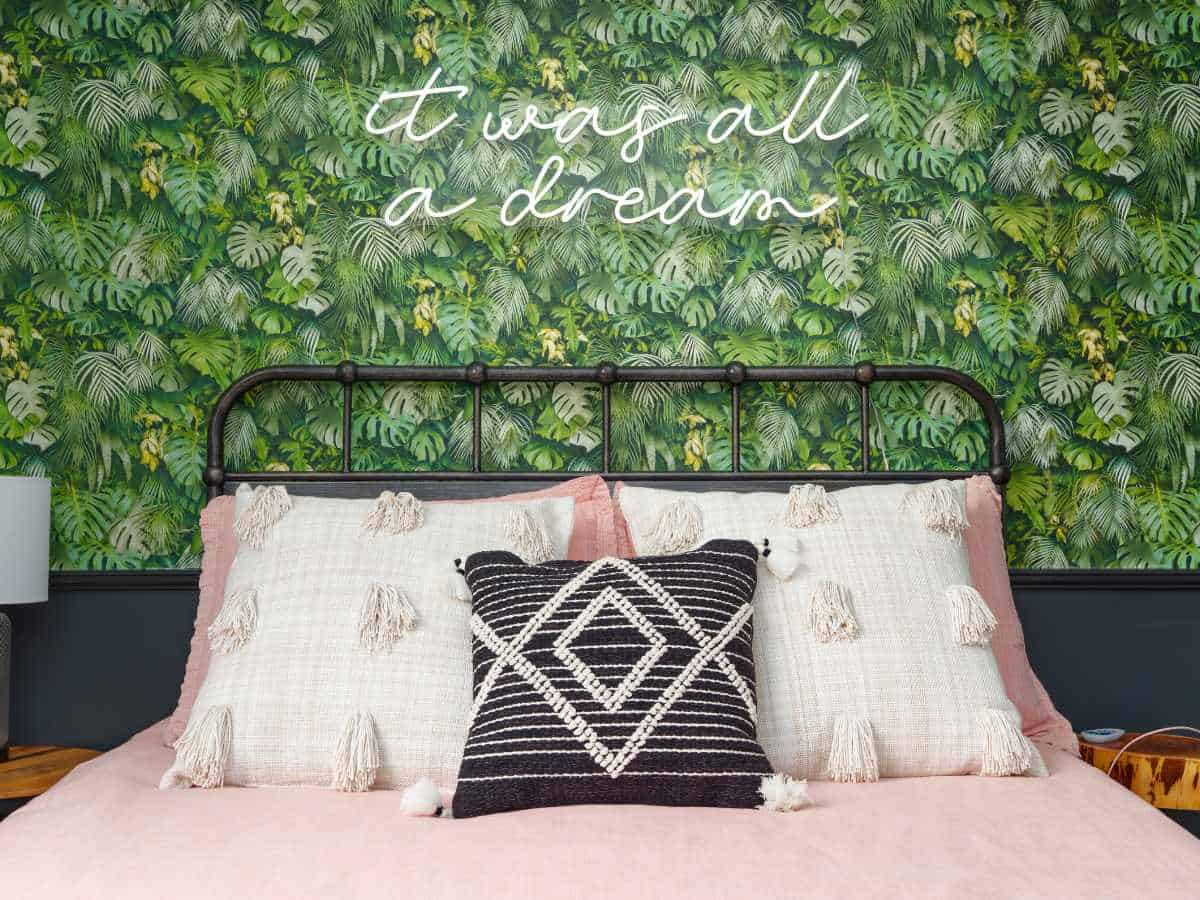 Elegant bedroom with lush green wall decor and cozy bedding.