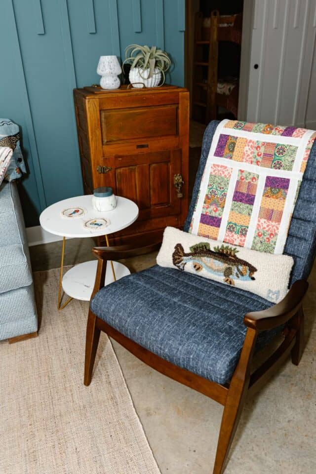 Comfortable armchair with colorful quilt and decorative pillow in a charming living space.