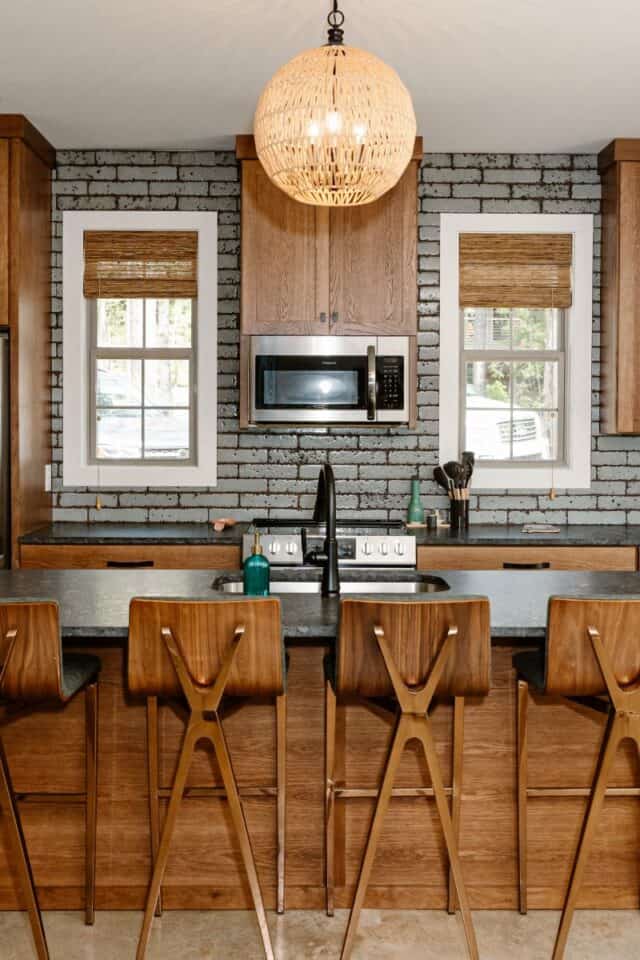 Kristen McGee Interiors modern kitchen featuring brick wall and wooden accents.