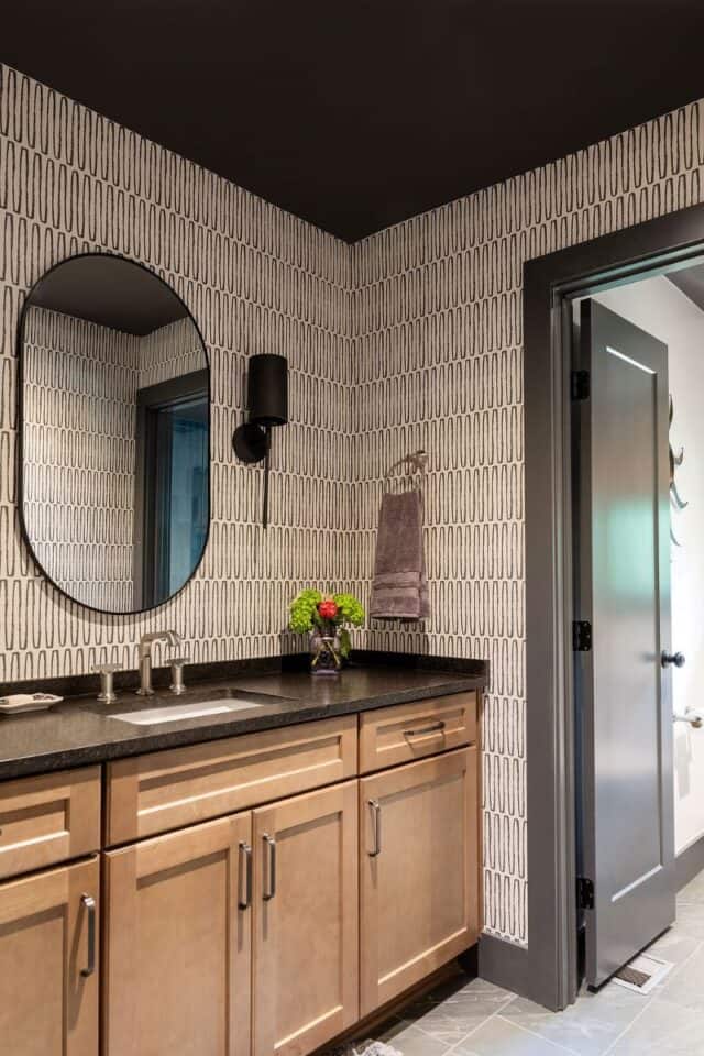 Bathroom vanity with black countertop and wooden cabinets in a stylish Birmingham home.