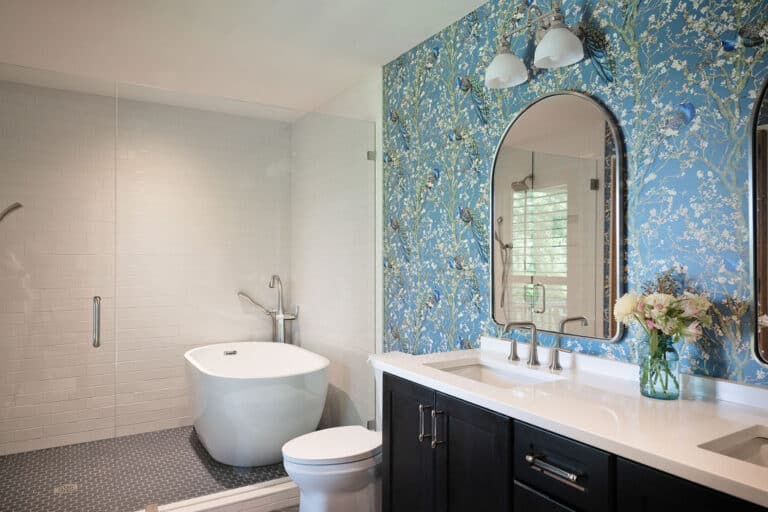 Elegant bathroom with freestanding tub and vibrant wallpaper.