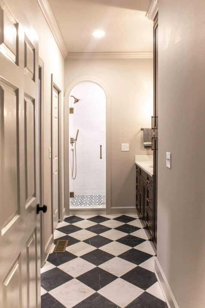 Primary suite bathroom with walk-in shower and elegant black-and-white checkered flooring.