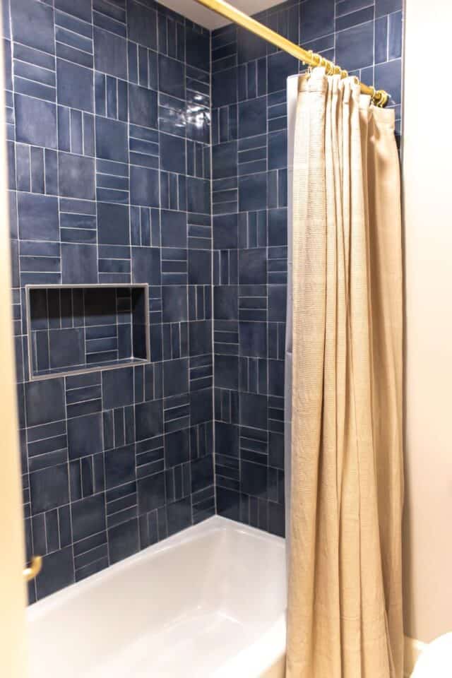 Blue tiled shower with built-in niche in Pelham primary suite bathroom.