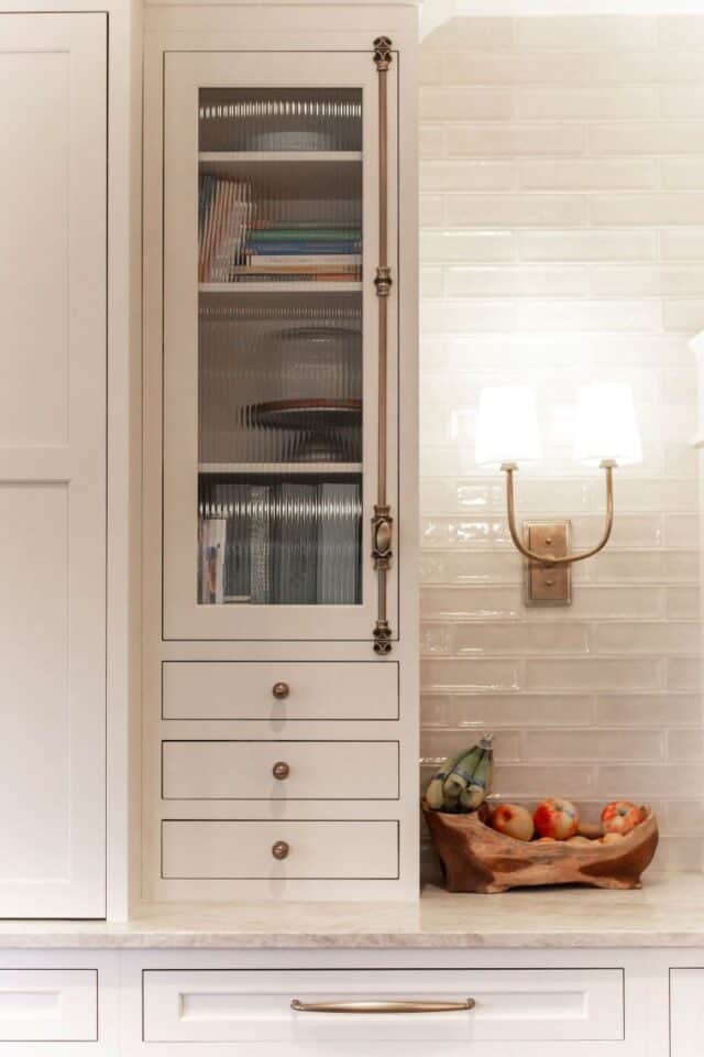 Elegant kitchen cabinet with glass doors and storage drawers.
