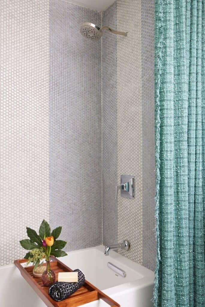 Modern guest nook shower with textured tiles and teal curtains for a stylish 2024 Birmingham home.