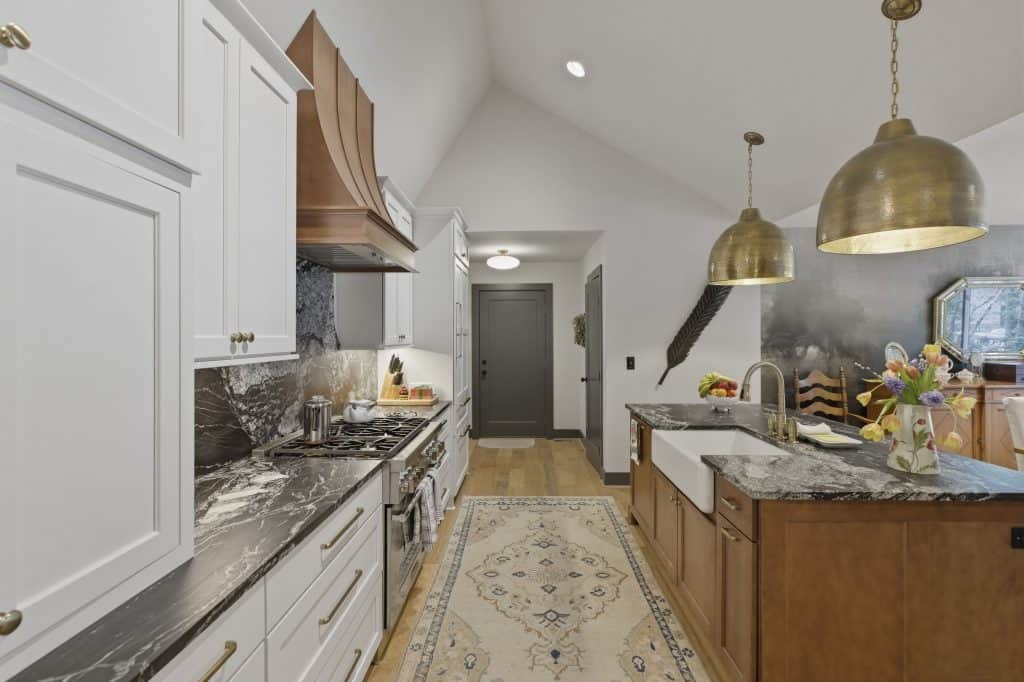 Bright Birmingham home kitchen with white cabinetry and elegant marble surfaces.