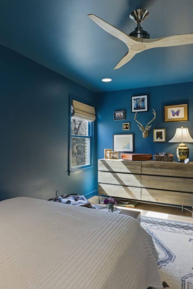 Modern bedroom with vibrant blue walls and stylish decor.