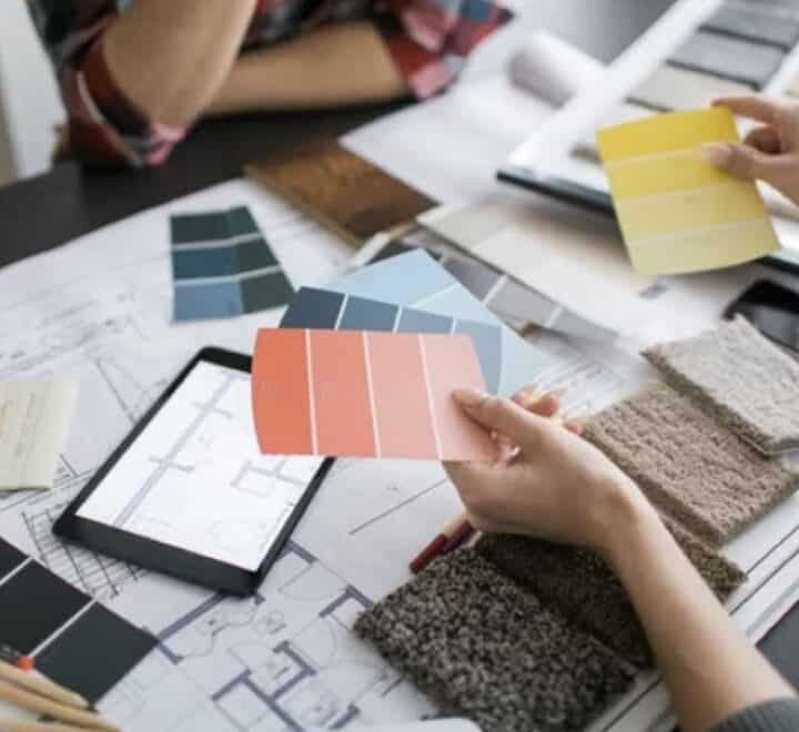 Interior design team reviewing color samples and fabric swatches for Kristen McGee Interiors project.