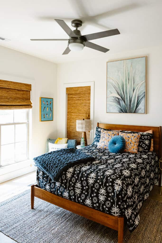 Cozy bedroom featuring a wooden bed, patterned bedding, and natural light in a lakeside home.