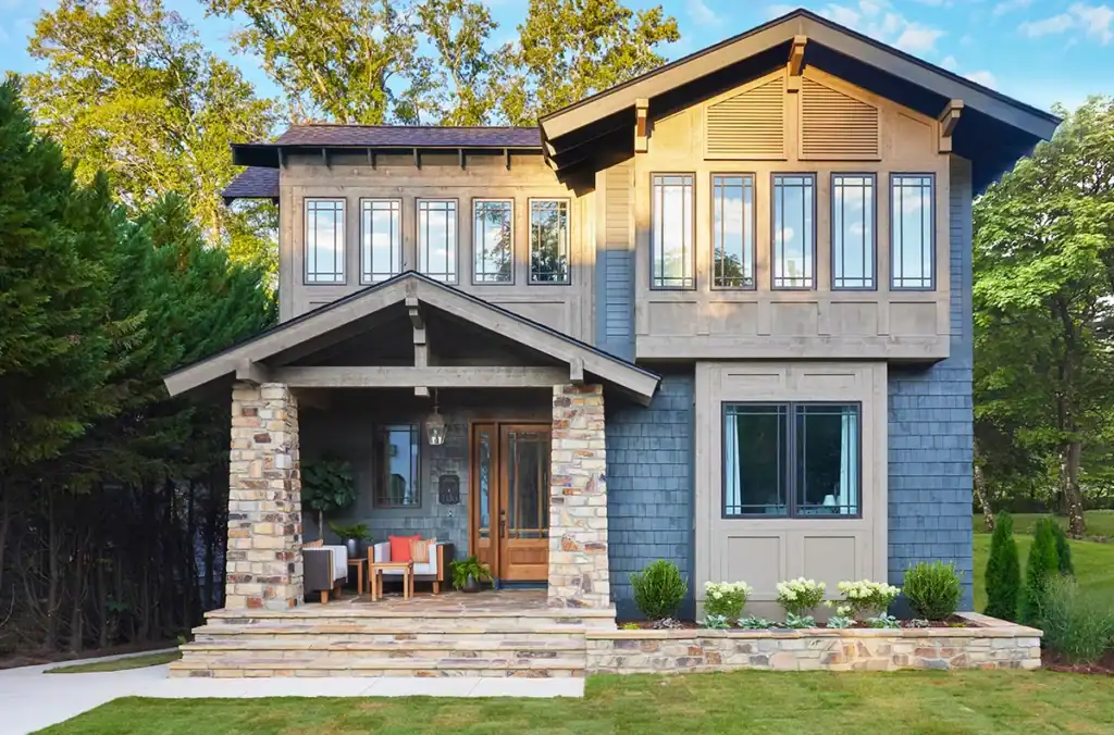 Contemporary Kristen McGee Interiors house with large windows and inviting porch.