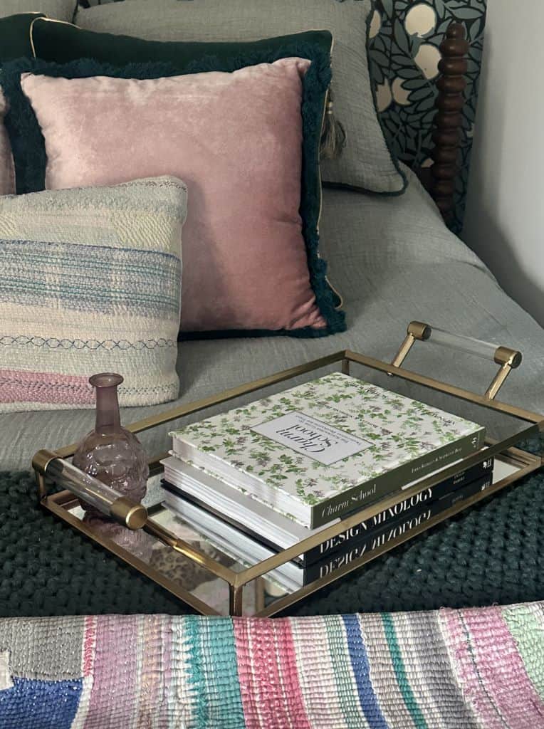 Elegant bedroom decor with plush pillows and decorative tray.