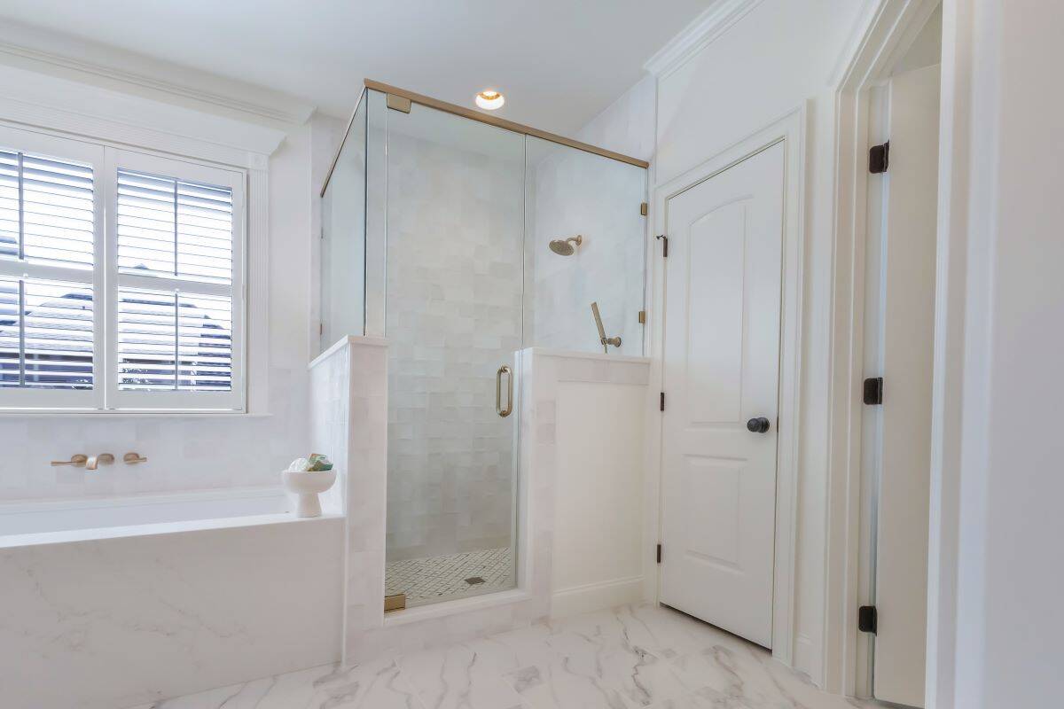 Modern Highland Lakes bathroom with a glass shower enclosure and elegant white finishes.