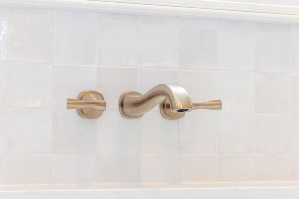 Elegant brushed nickel bathroom faucet with matching handles in Highland Lakes bathroom transformati.