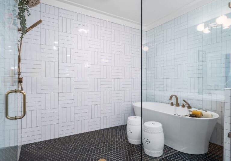 Elegant bathroom featuring white geometric tile walls and a stylish freestanding bathtub. Perfect fo.