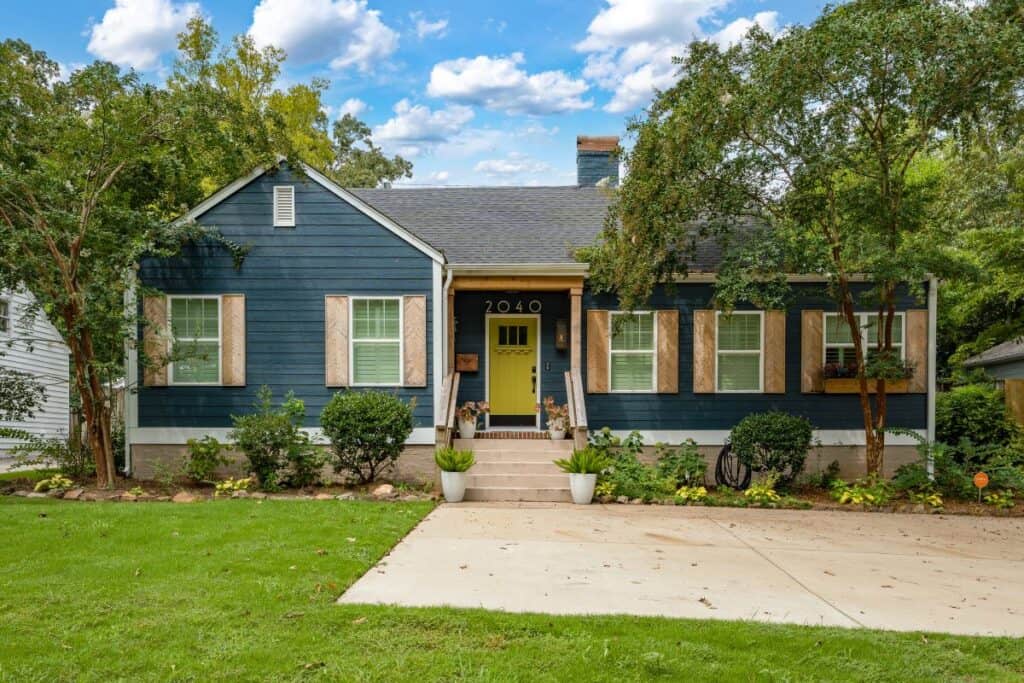Beautiful blue house with white trim and lush front yard in Birmingham.