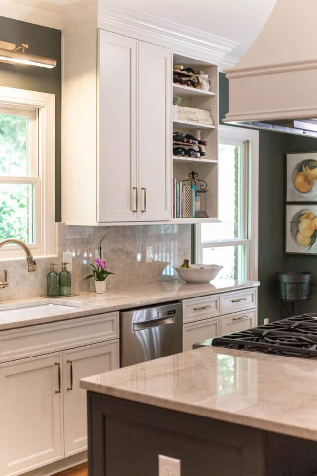 Bright kitchen with white cabinets, marble countertops, and stainless steel appliances.