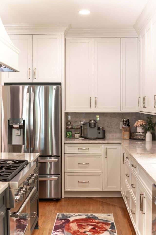 Bright white kitchen with stainless steel appliances and organized countertops.