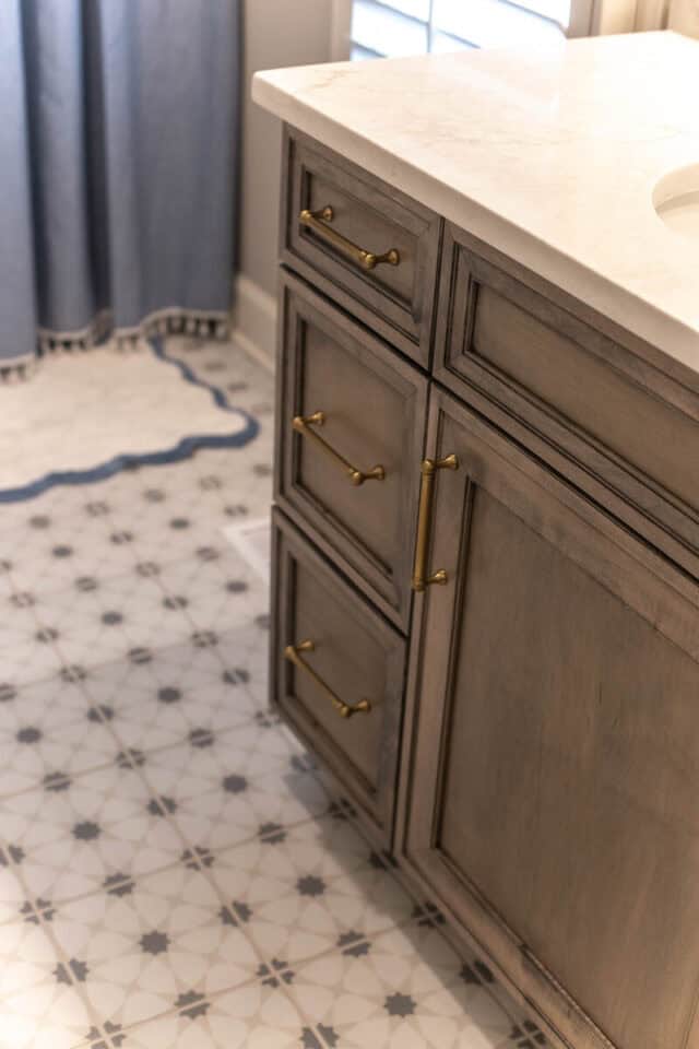 Bathroom vanity with gold hardware and marble countertop in a modern home.